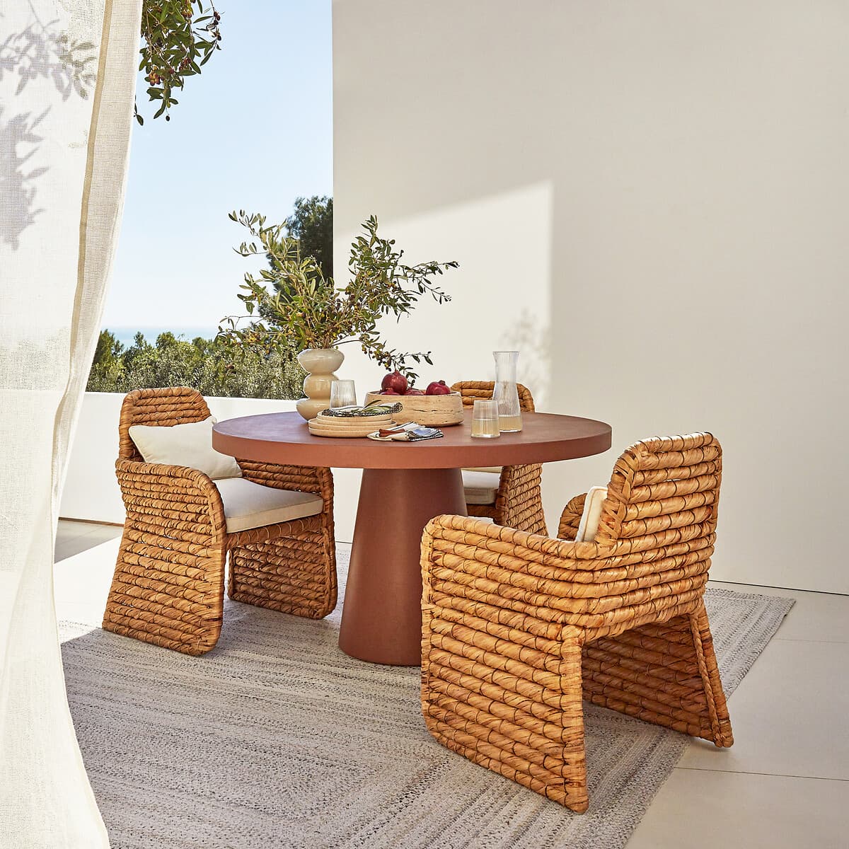 Mesa de comedor redonda terracota y sillas de ratán