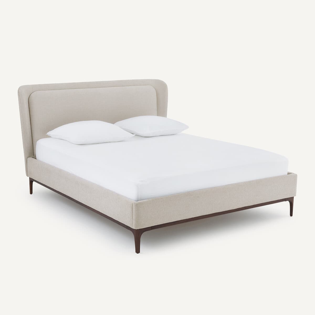 Cama tapizada beige con patas de madera