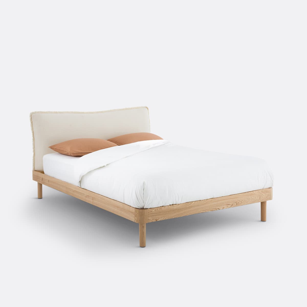 Cama de madera clara con cabecero tapizado beige