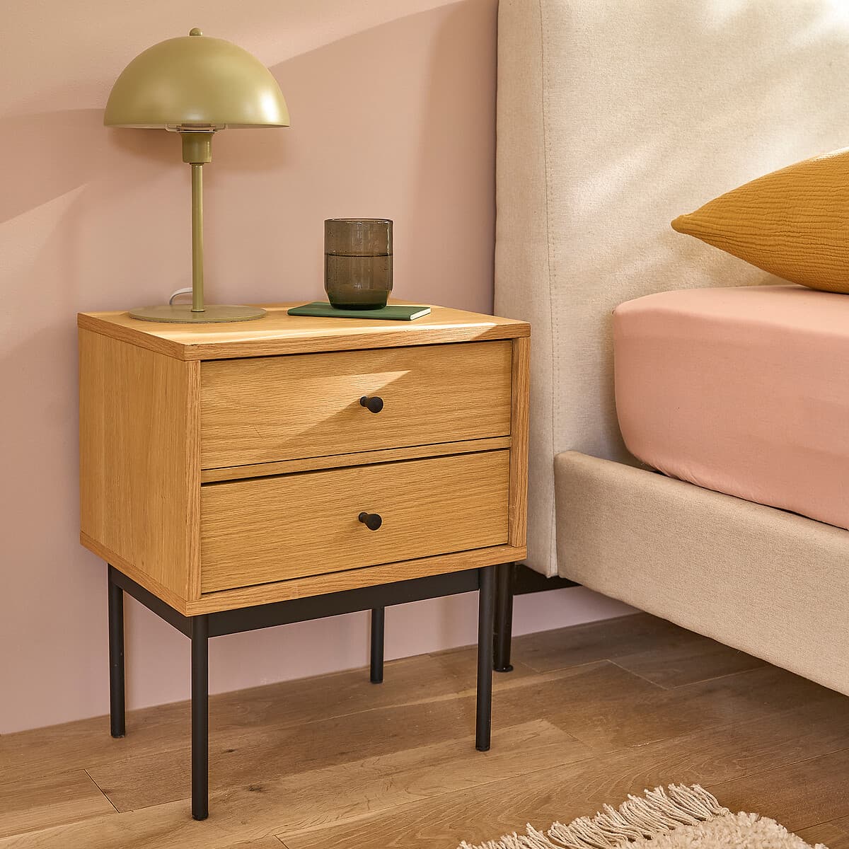 Mesita de noche de madera clara con cajones y patas negras