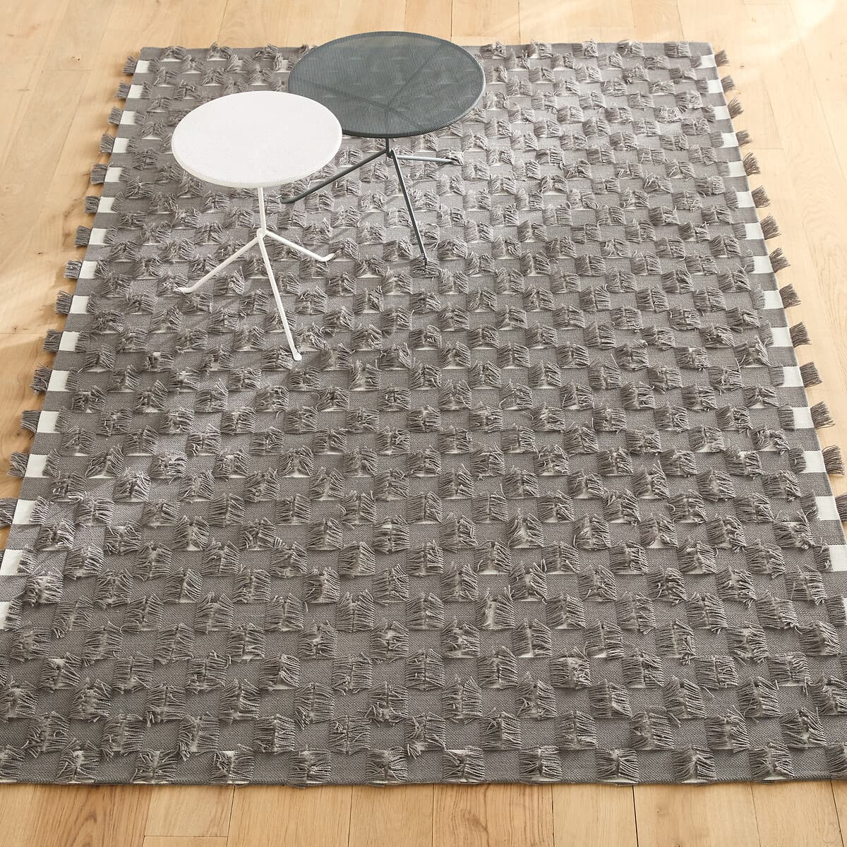 alfombra gris con textura, alfombra algodón borlas